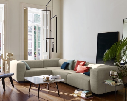 Beige modulare Eckcouch mit farbigen Kissen in modernem Wohnzimmer, erhältlich im Online-Shop für Sofas.