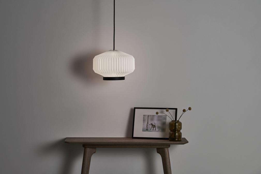 Shibui Pendelleuchte von Le Klint: Hängende Lampe mit plissiertem Lampenschirm und schwarzem Detail.
