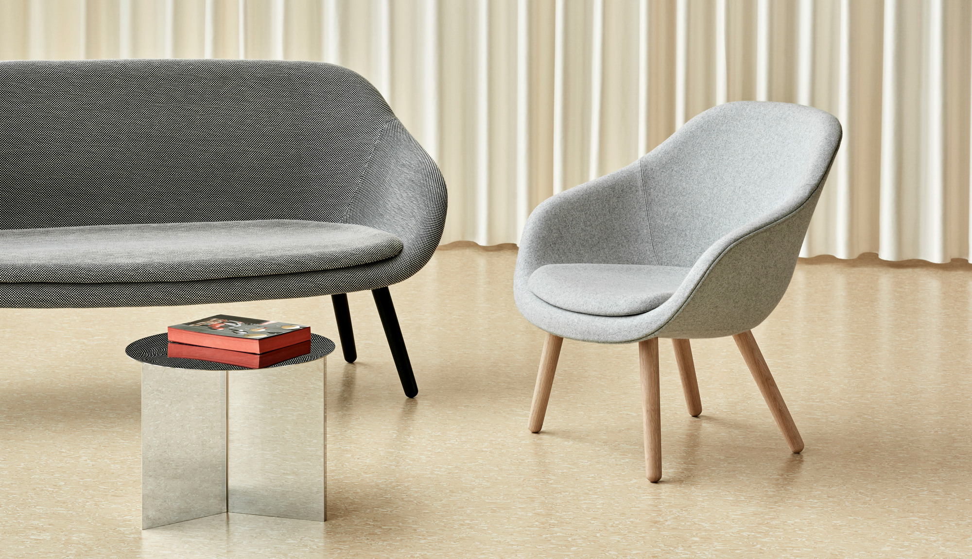 Graues About a Lounge Sofa von Hay mit passendem Sessel und Beistelltisch im modernen Wohnzimmer.