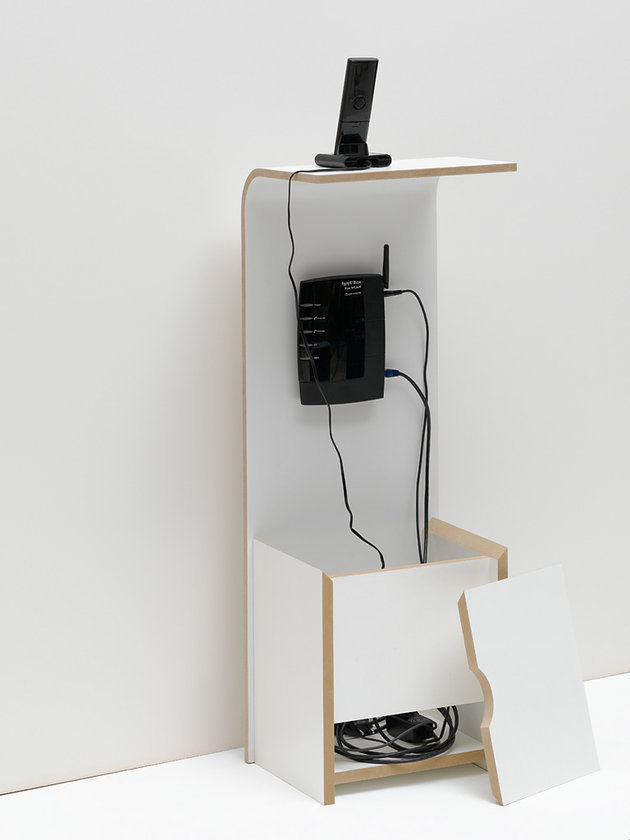 Weißes Fon Regal von Tojo mit Router, Telefon und Kabelsalat zur Aufbewahrung.