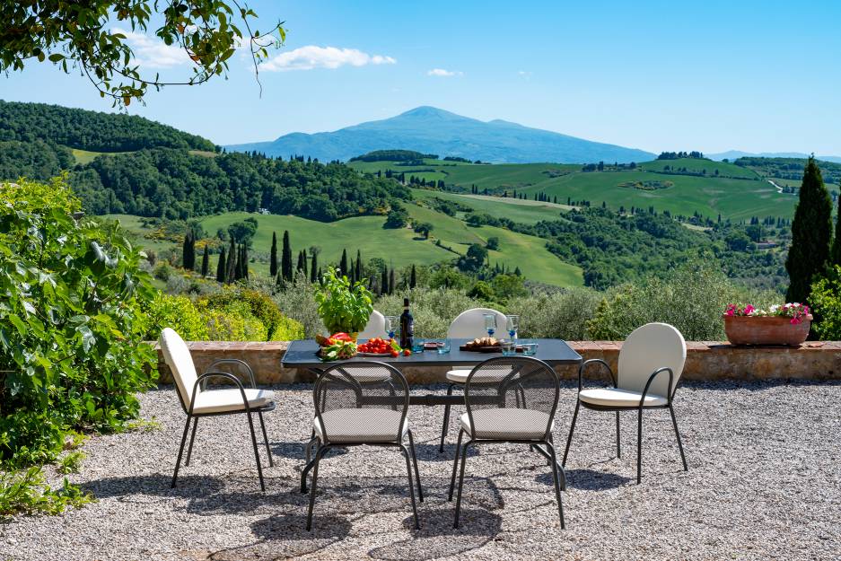 Ronda Stuhl von Emu für den Outdoor-Bereich, mit Esstisch und malerischer Landschaft.
