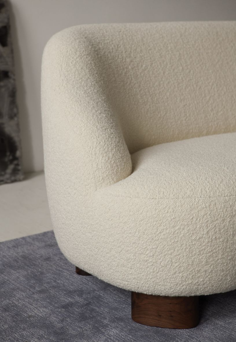 Detailaufnahme des Margas Sofas von AndTradition, ein cremefarbenes 2-Sitzer Sofa mit Bouclé-Bezug und dunklen Holzfüßen.