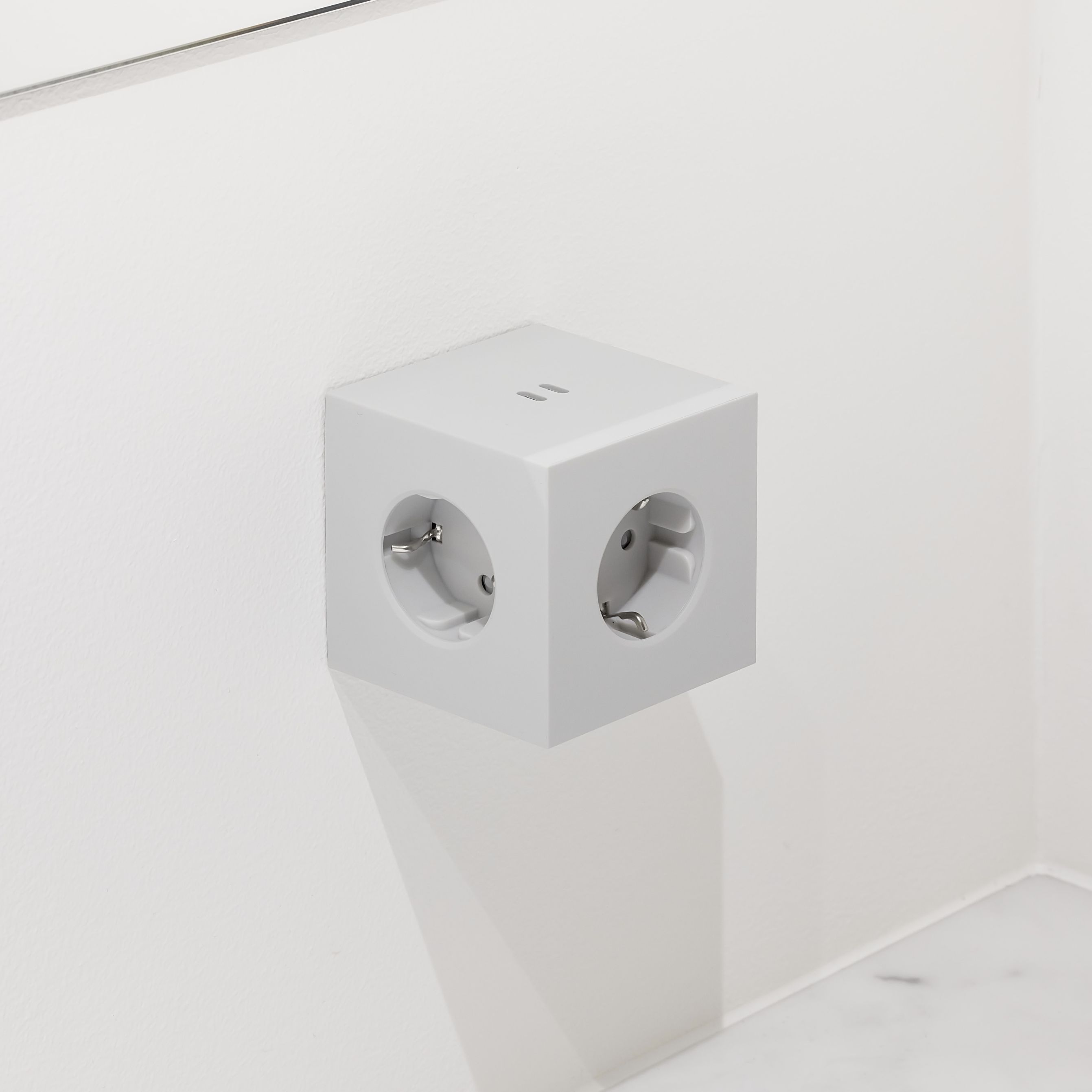 Grauer Avolt Square 2 Steckdosenwürfel mit USB-C Anschlüssen an weißer Wand. Design Steckdose.