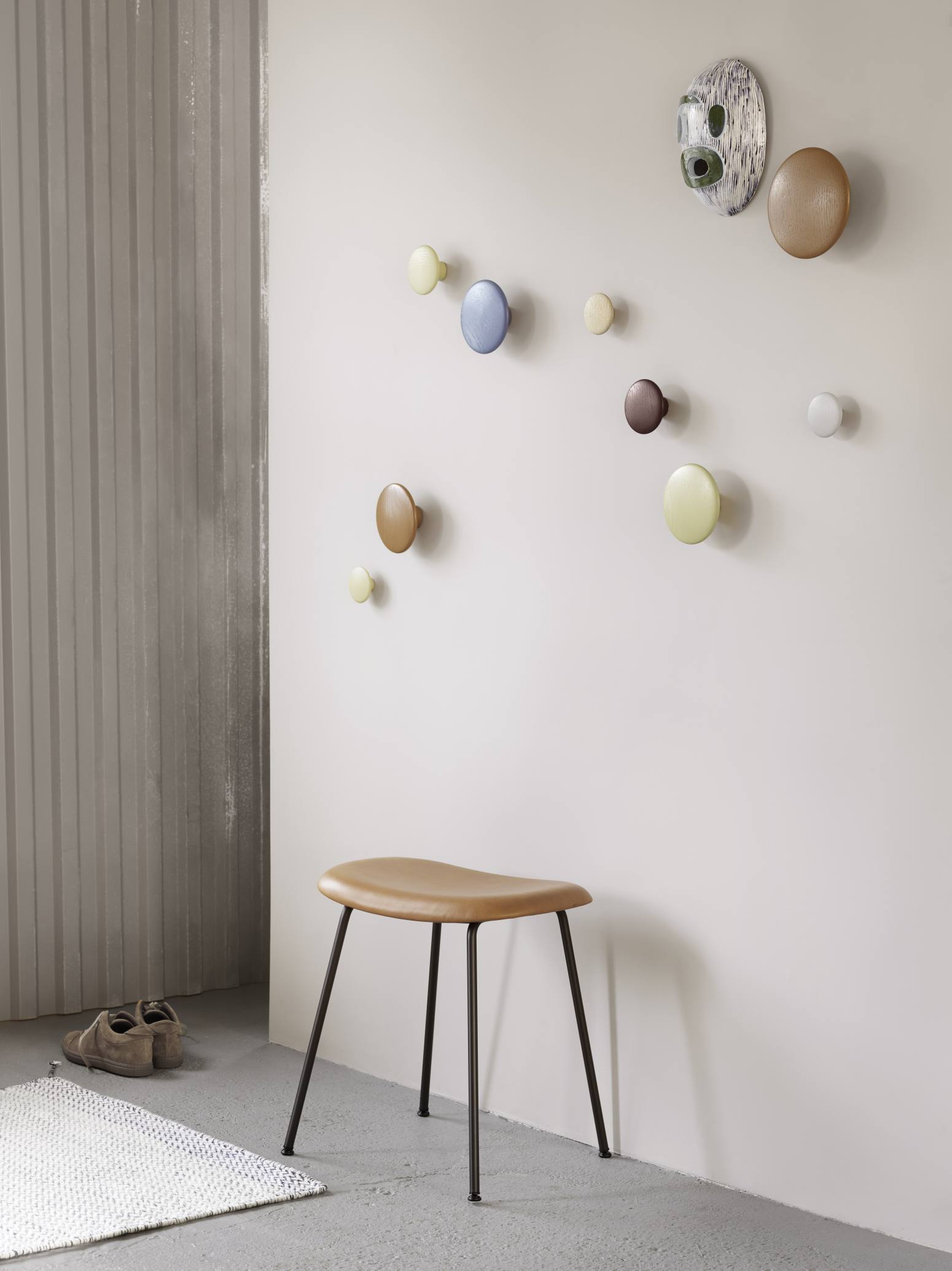 Wand mit verschiedenen The Dots Holz Garderobenhaken von Muuto in Weiß, Braun, Blau und Grün.
