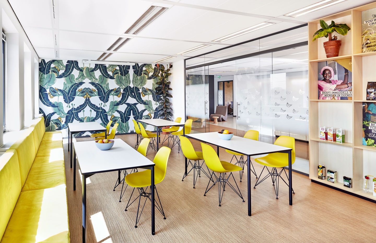 Helles Büro mit mehreren gelben Eames DSR Stühlen von Vitra an weißen Tischen.
