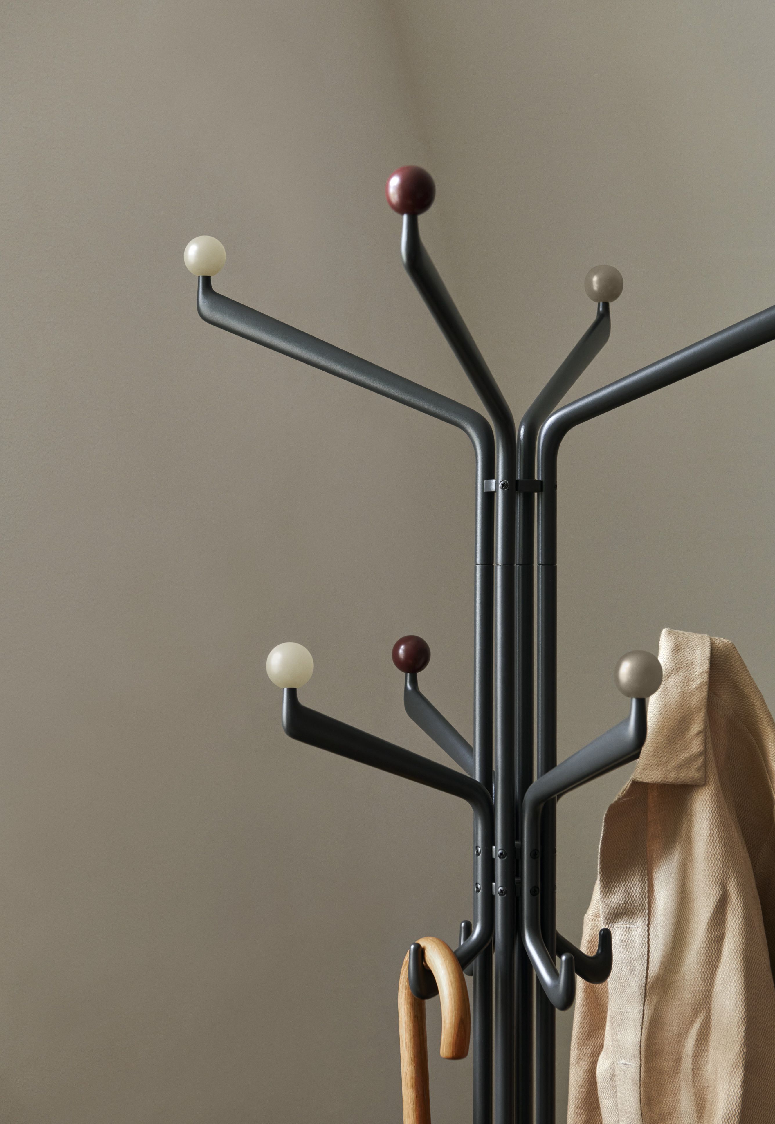 Detailaufnahme des AndTradition Capture SC77 Kleiderständers in Grau mit Jacke und Schirm. Design-Garderobe für Flur und Diele.