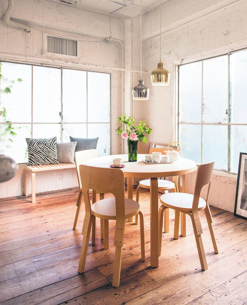 Esszimmer mit A330S Golden Bell Pendelleuchten von Artek in Gold und Silber über Holztisch.