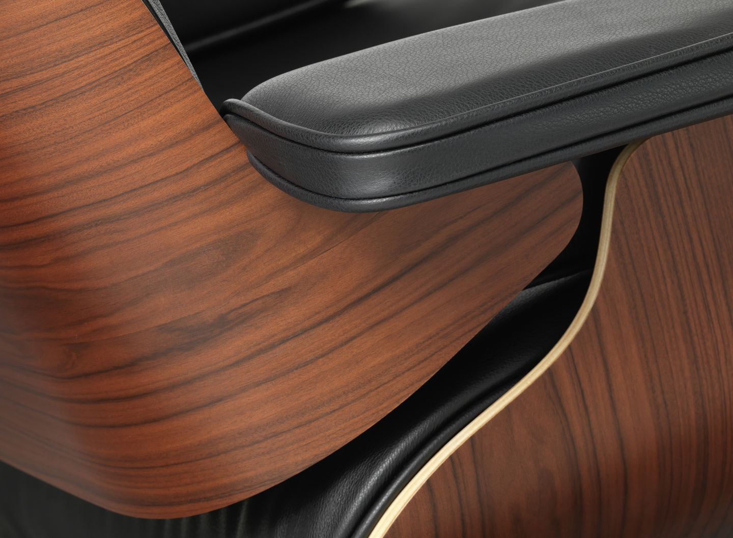 Detailaufnahme: Eames Lounge Chair mit schwarzem Leder und Nussbaumholz, Designklassiker für stilvolles Wohnen.
