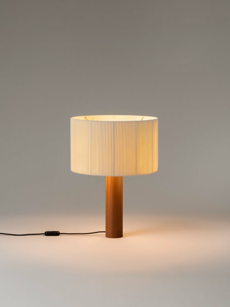 Moragas Leuchte: Elegante Tischleuchte mit plissiertem Lampenschirm und Holzfuß für stimmungsvolle Beleuchtung.