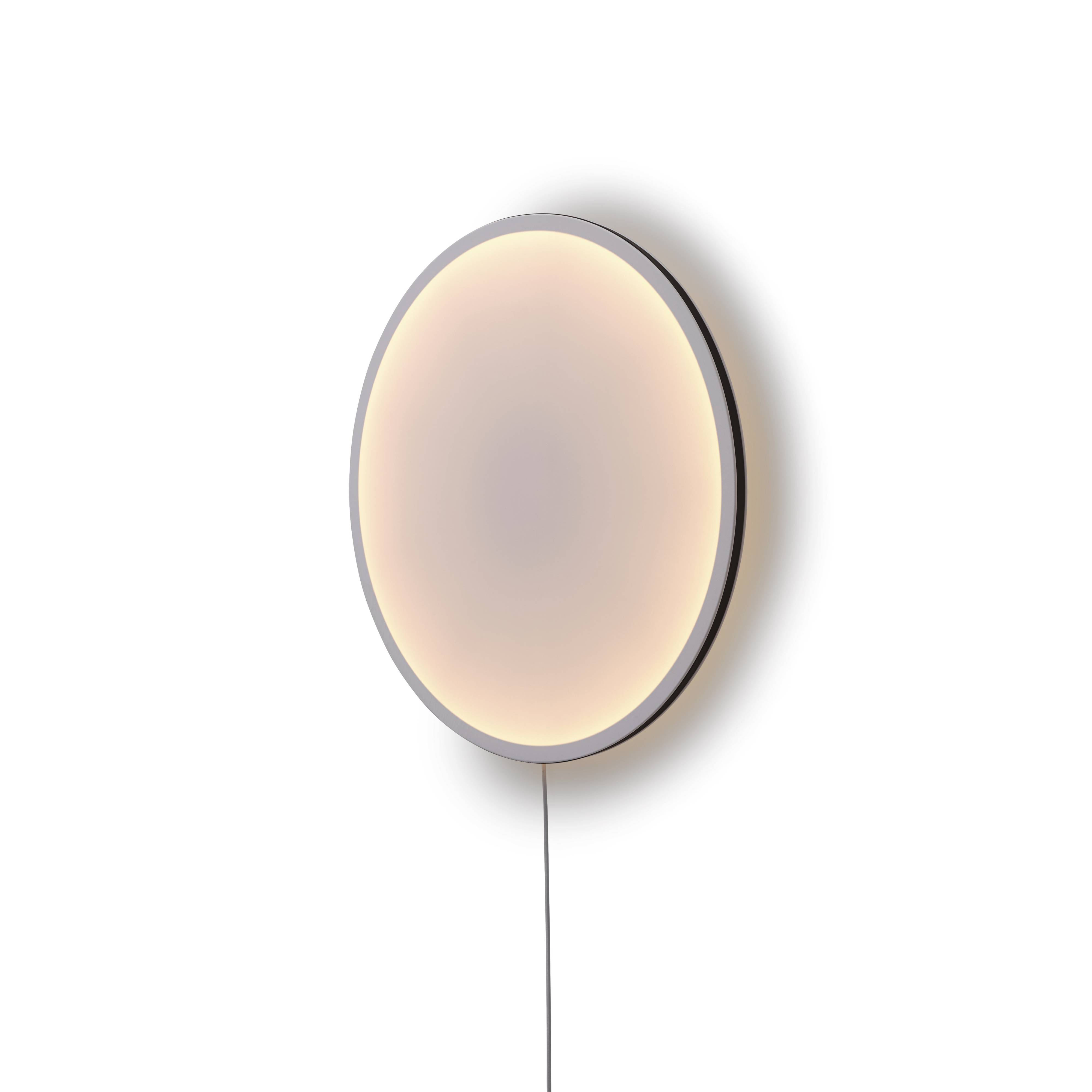 Calm Wandleuchte von Muuto, runde, moderne Lampe mit sanftem Lichtschein an weißer Wand.