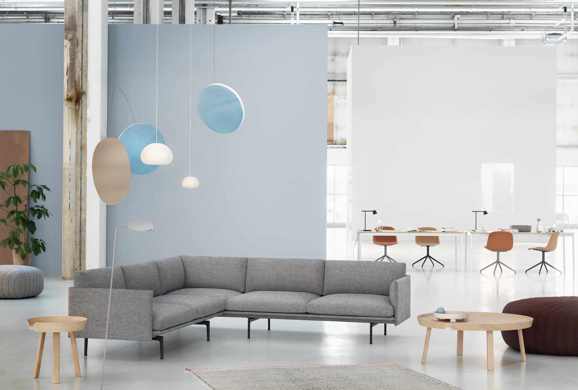 Heller Raum mit grauem Ecksofa und Around Coffee Table Large Couchtisch Eiche von Muuto im Vordergrund.