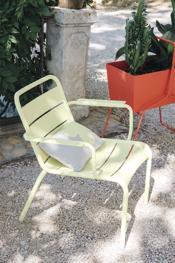 Heller Luxembourg Lounge Sessel von Fermob mit Kissen im Garten, Outdoor Möbel.