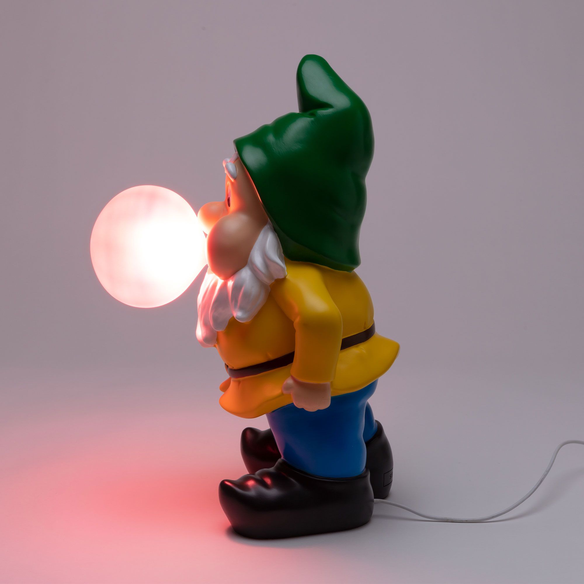 Seletti Gummy Working Leuchte: Gartenzwerg Lampe mit gelber Jacke, blauer Hose und leuchtender Kugel.