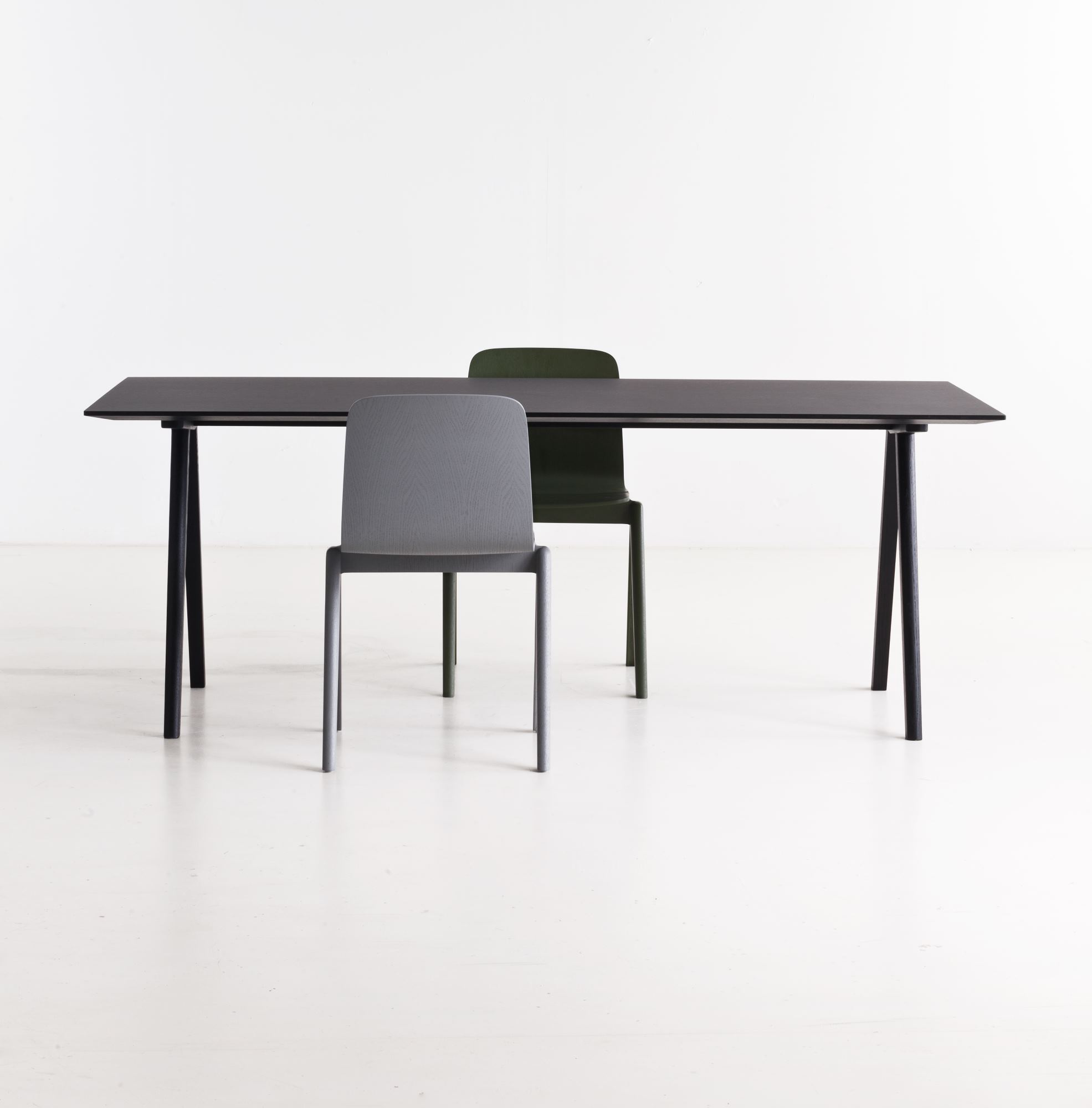 Schwarzer Copenhague Table CPH 10 Tisch von Hay mit zwei Stühlen vor einem weißen Hintergrund.