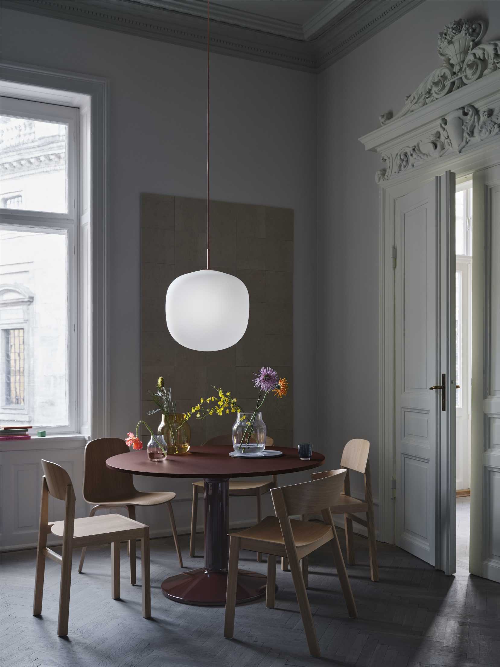 MIDST Table von Muuto: Runder Esstisch aus Holz mit Blumen in einem stilvollen Esszimmer.