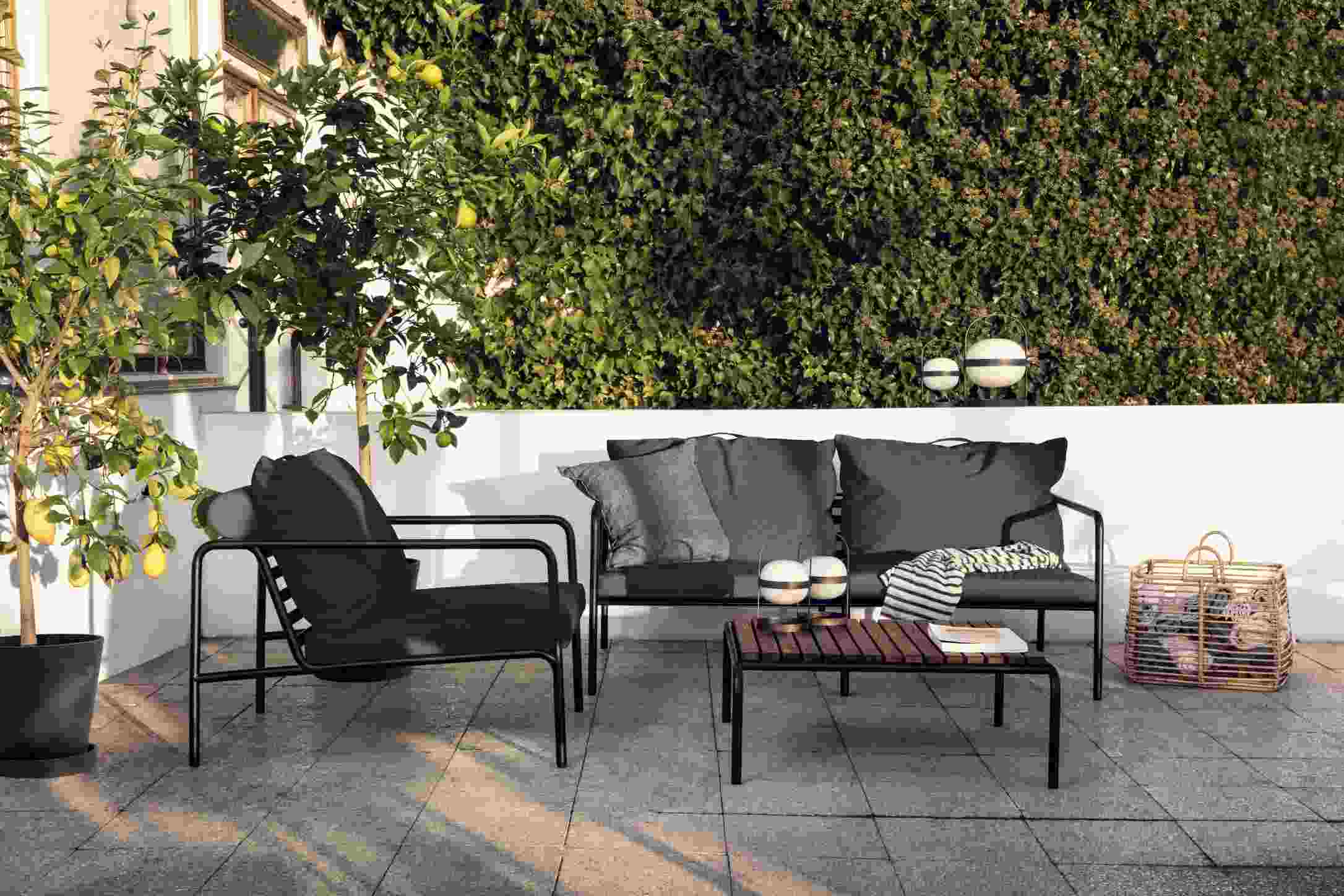 Avon 2-Sitzer Sofa von Houe für den Außenbereich mit Sessel und Tisch auf Terrasse.