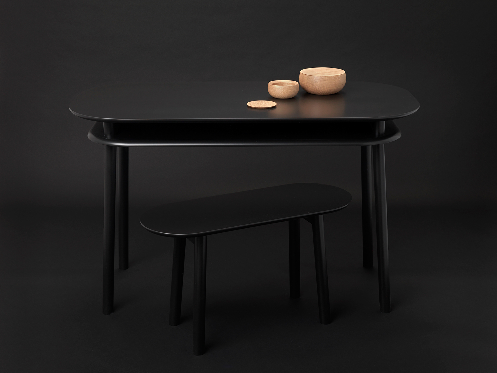 Schwarzer Schönbuch Schreibtisch mit Holzschalen und Hocker, minimalistisches Design für modernes Arbeitszimmer.