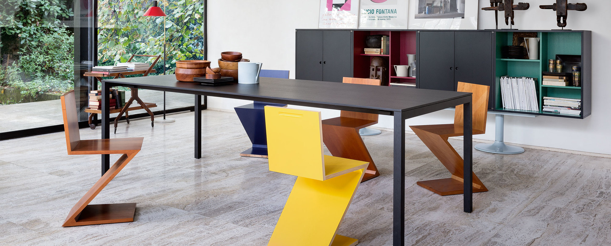Cassina Zig Zag Stühle in Gelb und Holz um einen Esstisch in modernem Interieur.