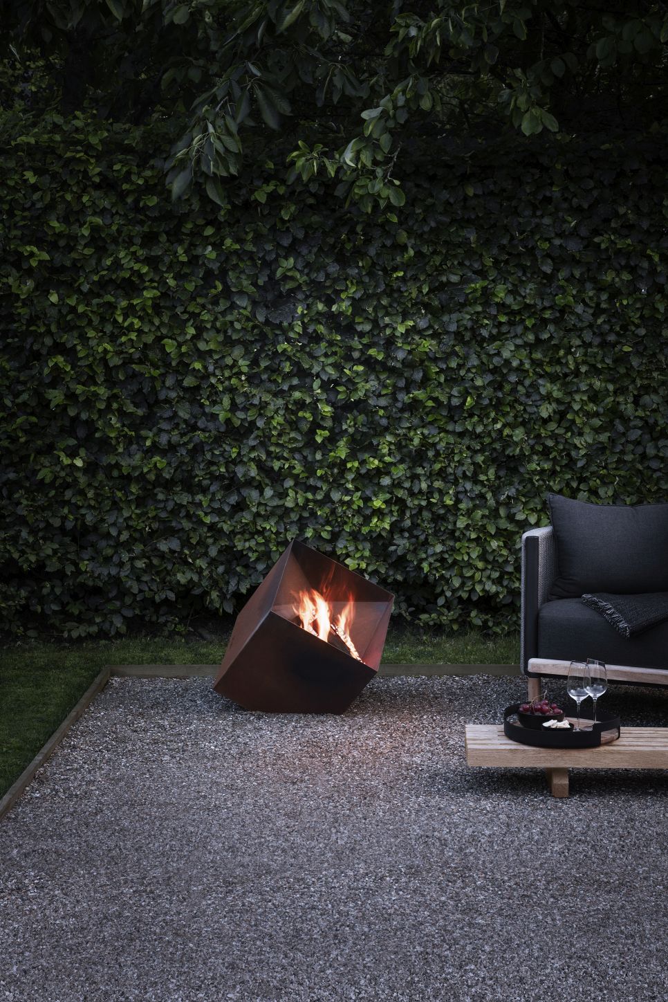FireCube Feuerschale: Kubistische Feuerstelle und Grill von Eva Solo im Garten mit Feuer.