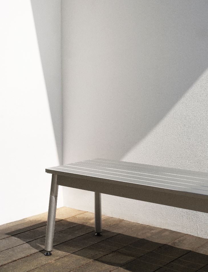 Silberne Ex Bank Outdoor von Normann Copenhagen vor einer weißen Wand mit Schattenwurf.