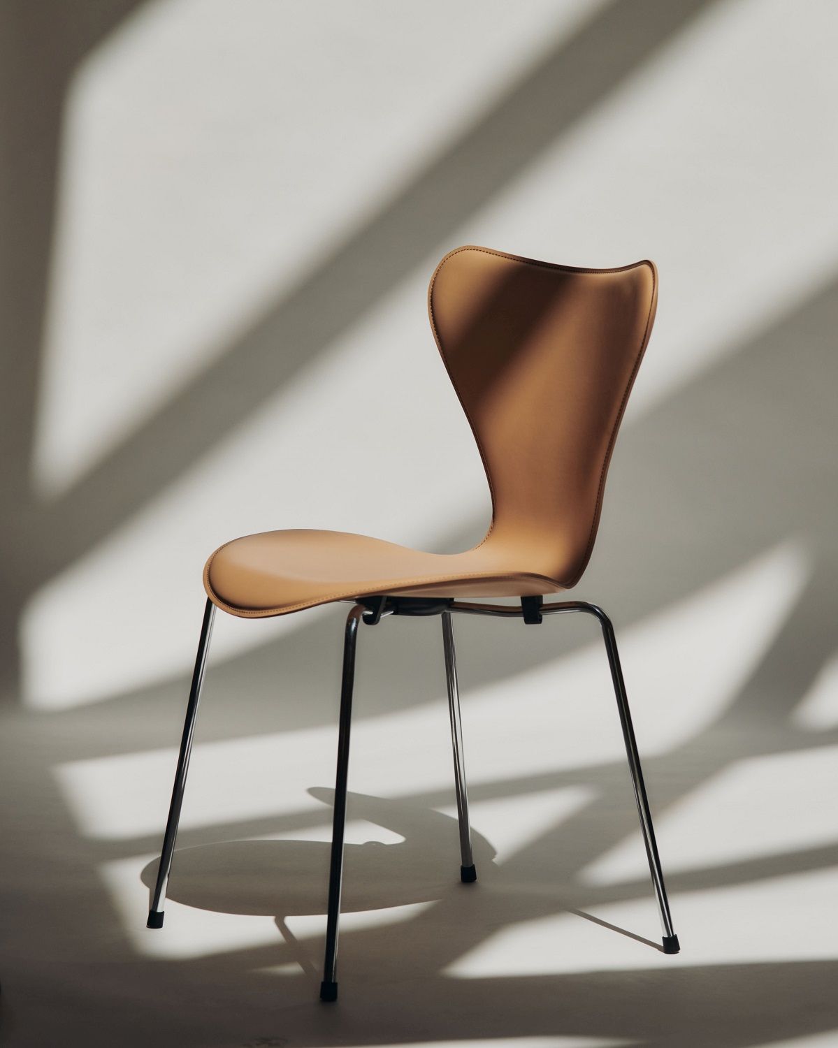 Fritz Hansen Siebener Stuhl mit Lederbezug in Cognac und Stahlbeinen, modernes Möbeldesign.