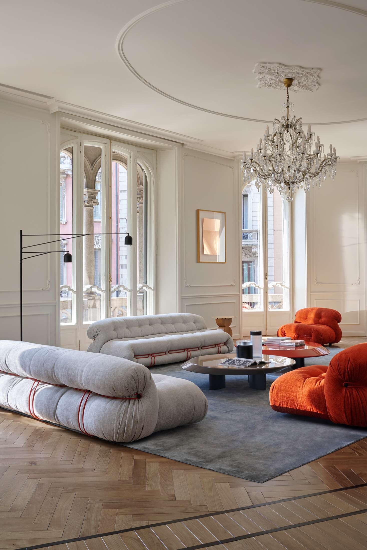 Helles Wohnzimmer mit Cassina Soriana Sessel in Orange und passendem Sofa in Beige.