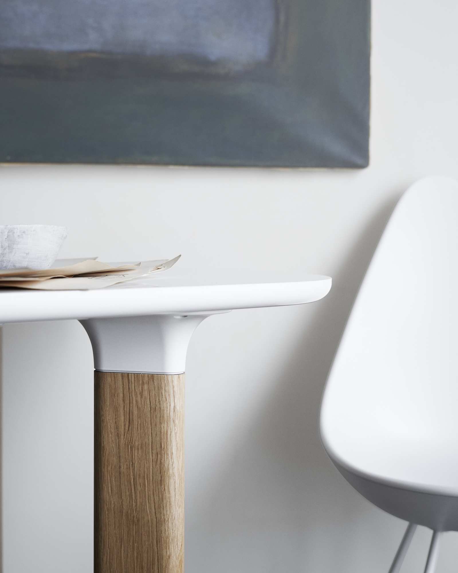Detailaufnahme des Fritz Hansen Analog Tischs mit weißer Tischplatte und Holzfuß, minimalistisches Design.