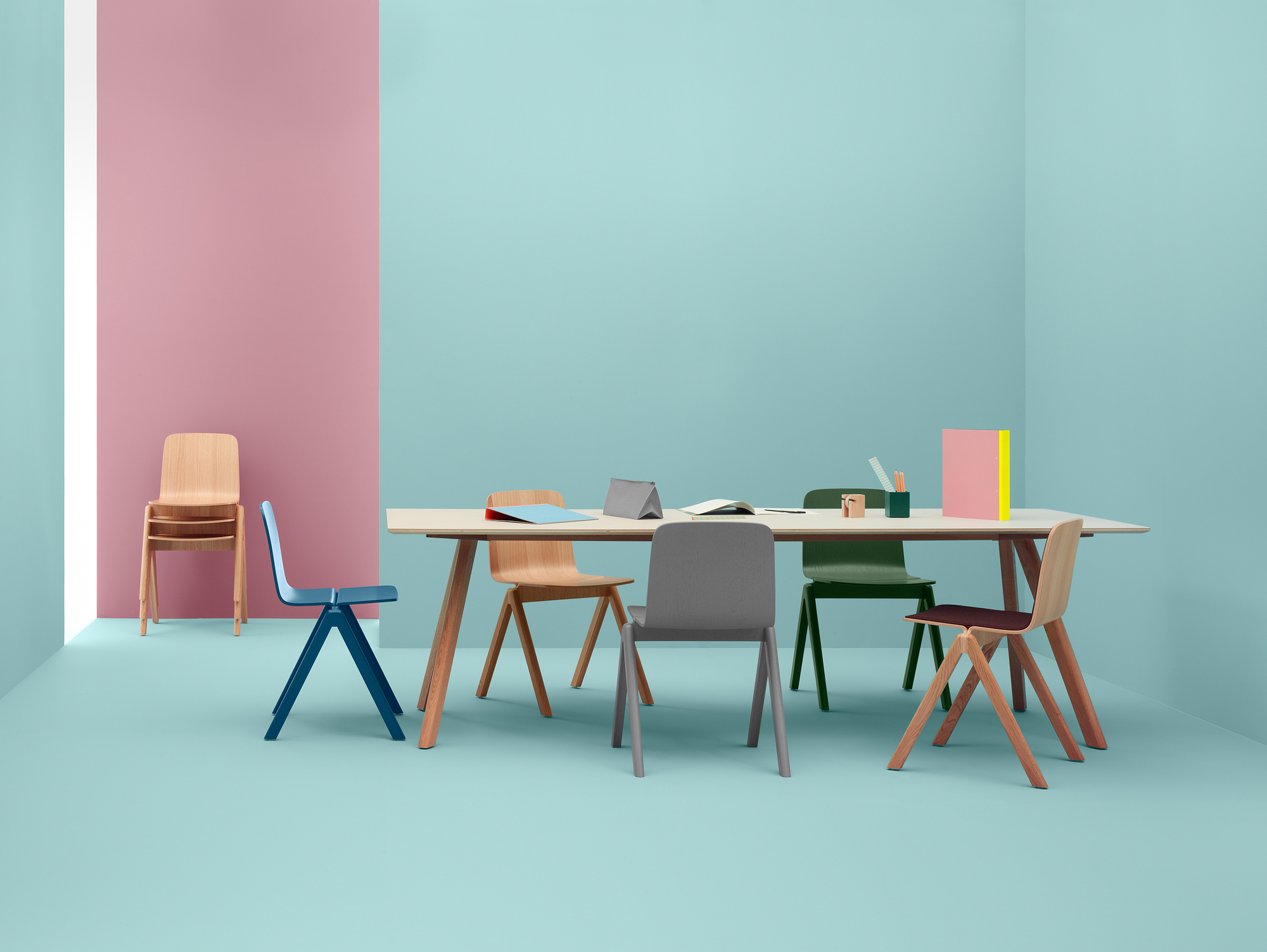 Heller Copenhague Table CPH 30 Tisch mit Holzbeinen und farbigen Stühlen in einem modernen Büro.