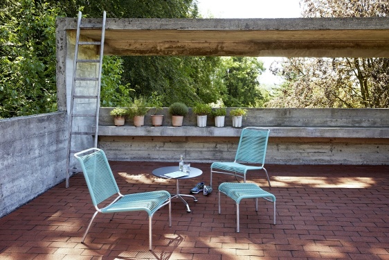 Altorfer Stuhl Outdoor Embru Weiß RAL 9016: Gartenstuhl aus Metall mit Fußhocker auf einer Terrasse.