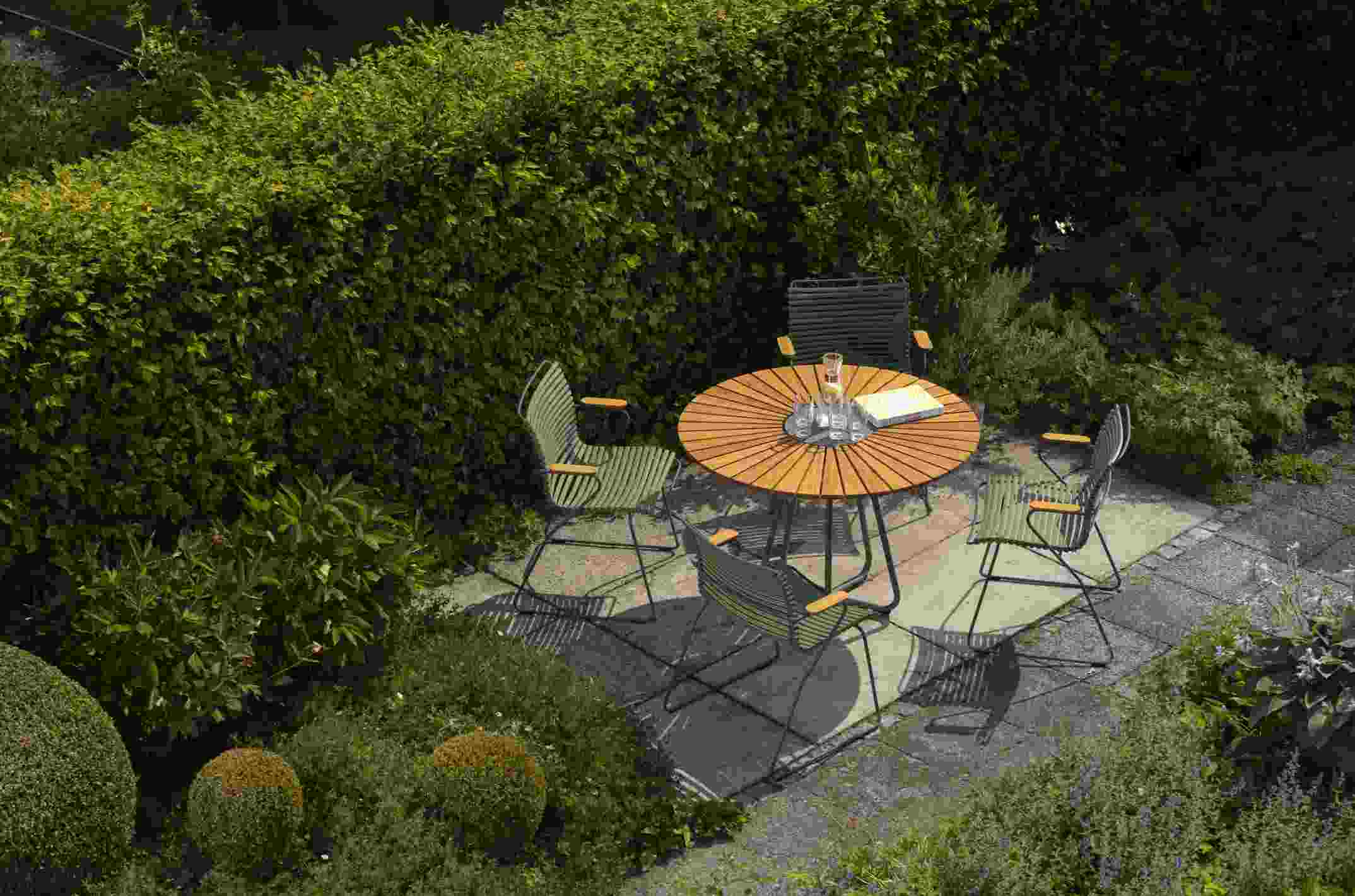Dunkelgraue Click Dining Stühle von Houe mit Armlehne und Holztisch im Garten, Outdoor Möbel.