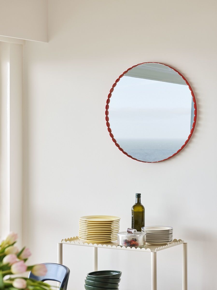 Runder Arcs Mirror von Hay mit rotem Rahmen an einer weißen Wand. Dekorative Spiegel.