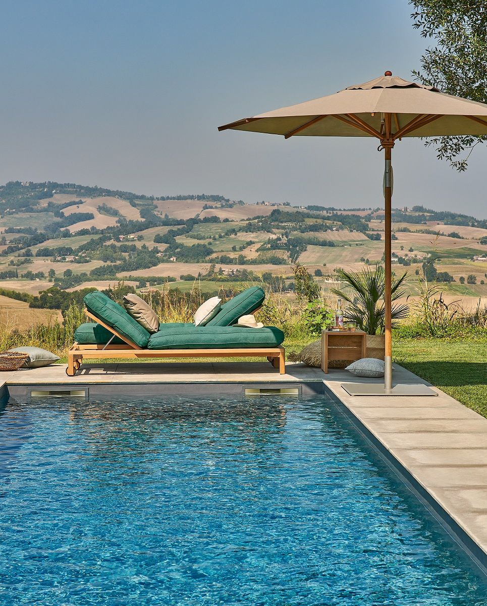 Weishäupl Teakschirm neben Pool und Liege, Sonnenschirm für Garten und Terrasse mit mediterranem Flair.