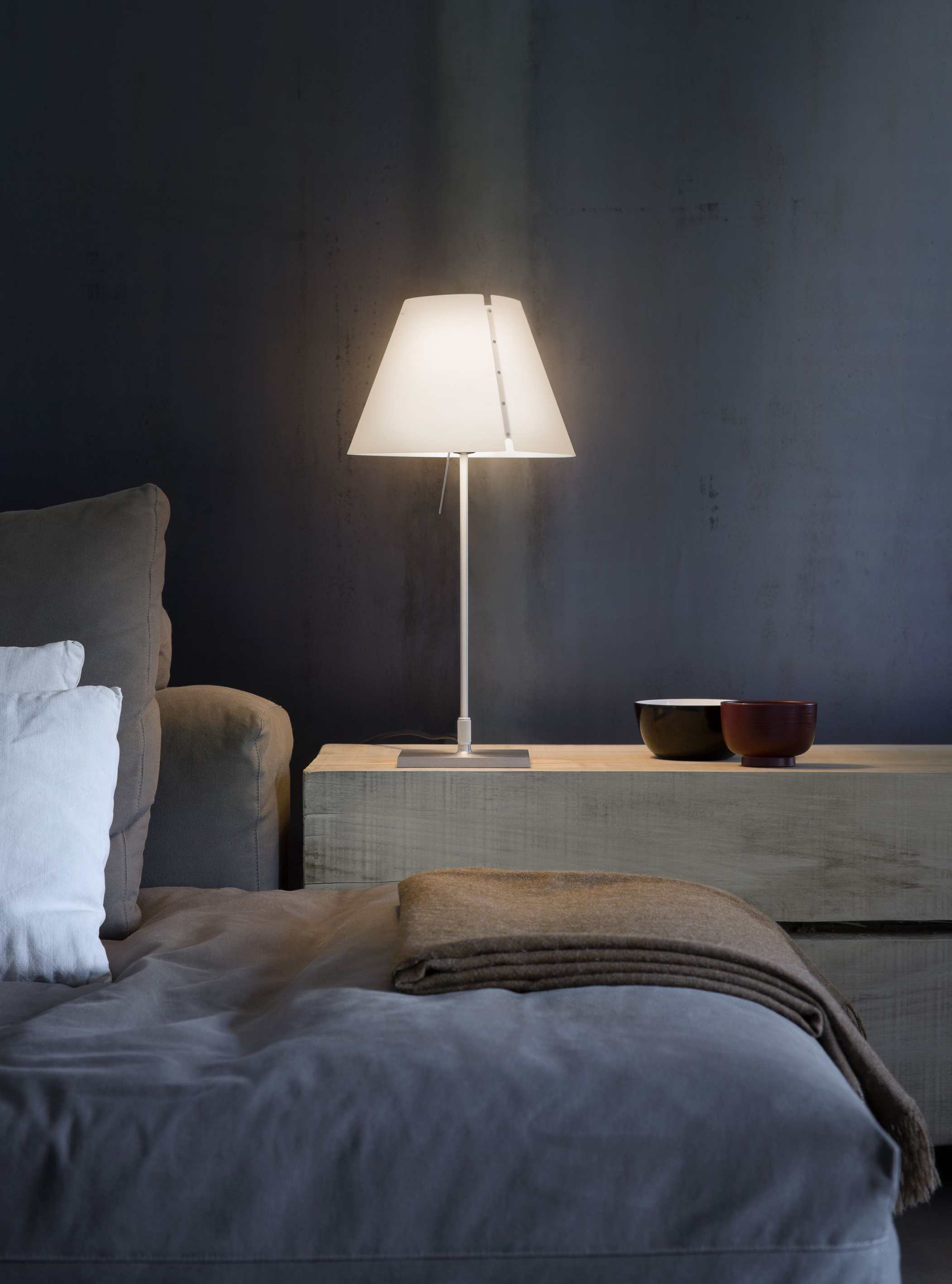 Costanzina Tischleuchte in Aluminium und Weiß auf Nachttisch neben Bett. Design Lampe.