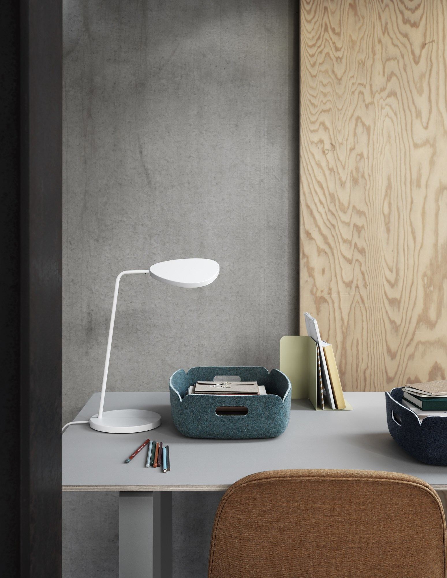 Muuto Restore Tray Basket in Schwarz Melange auf Schreibtisch mit Lampe und Büroartikeln.