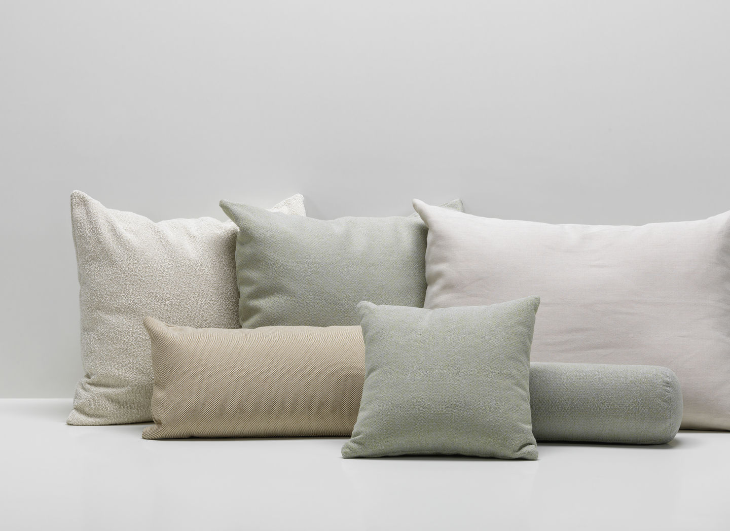 Vitra Kissen und Sofakissen in verschiedenen Formen und Texturen in Beige, Weiß und Grün.