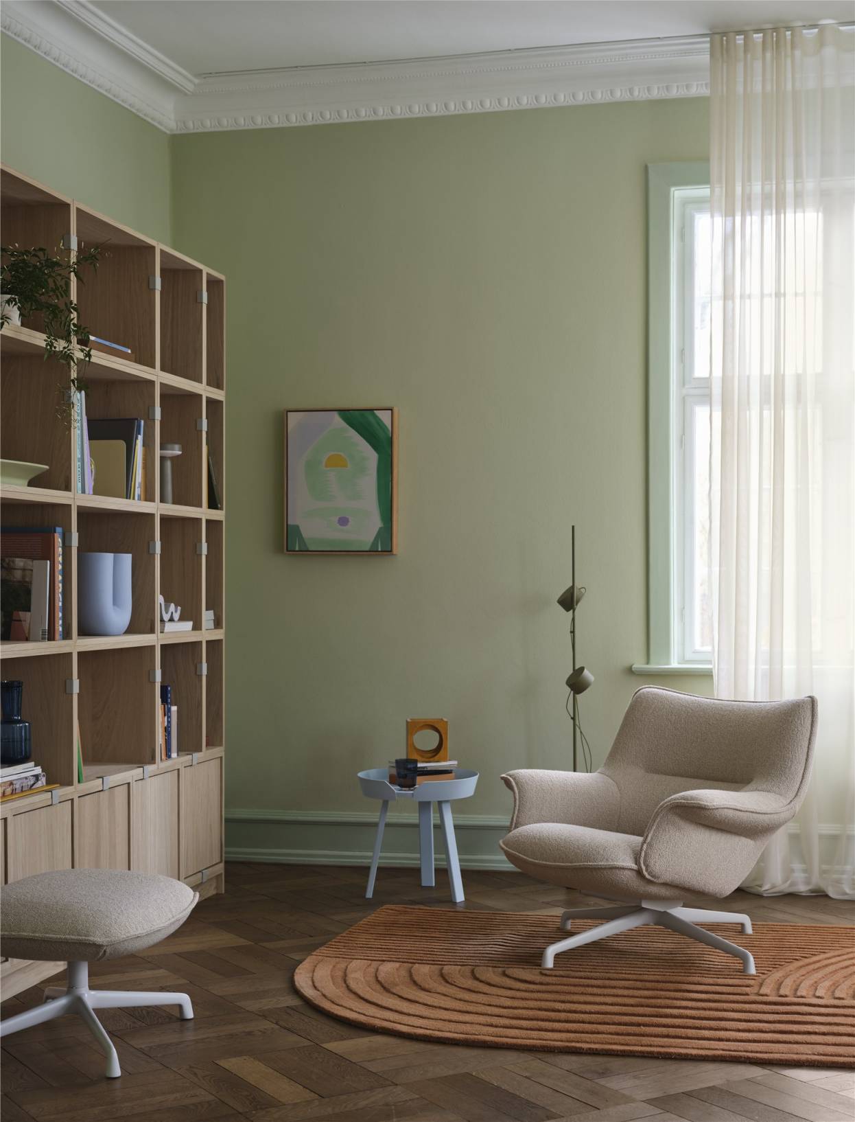 Beiger Muuto Doze Lounge Chair Low Sessel mit Hocker in stilvollem, grünem Wohnzimmer auf Teppich.