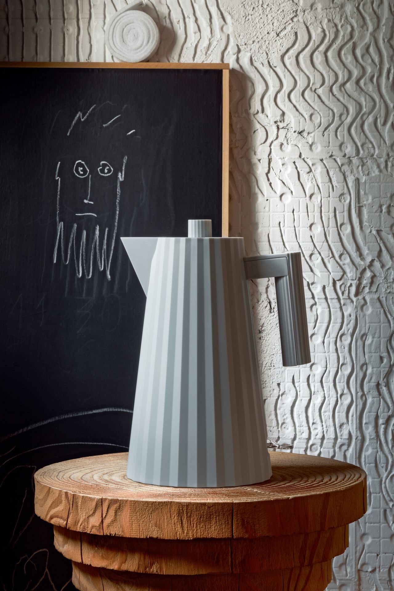 Graue Design-Teekanne mit Rillen auf einem Holztisch, moderne Teekanne für Teezubereitung im minimalistischen Stil.