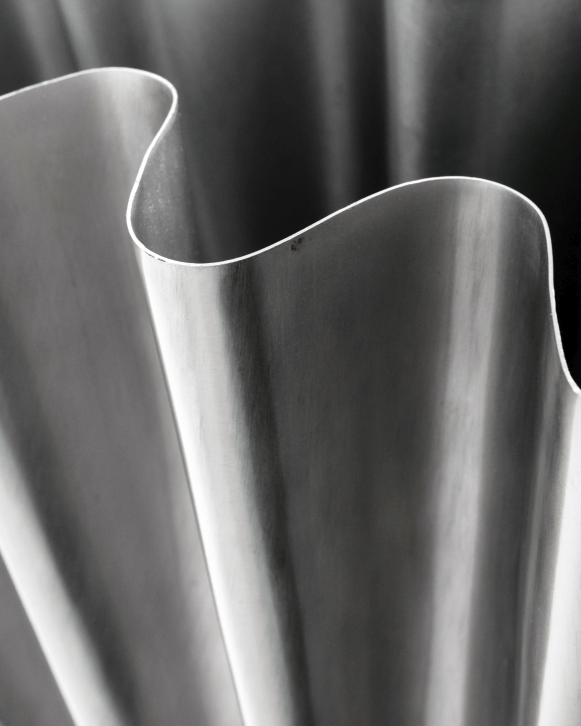 Detailaufnahme der Vase HDFlood von House Doctor mit gebürstetem Silber-Finish und wellenförmigem Design.