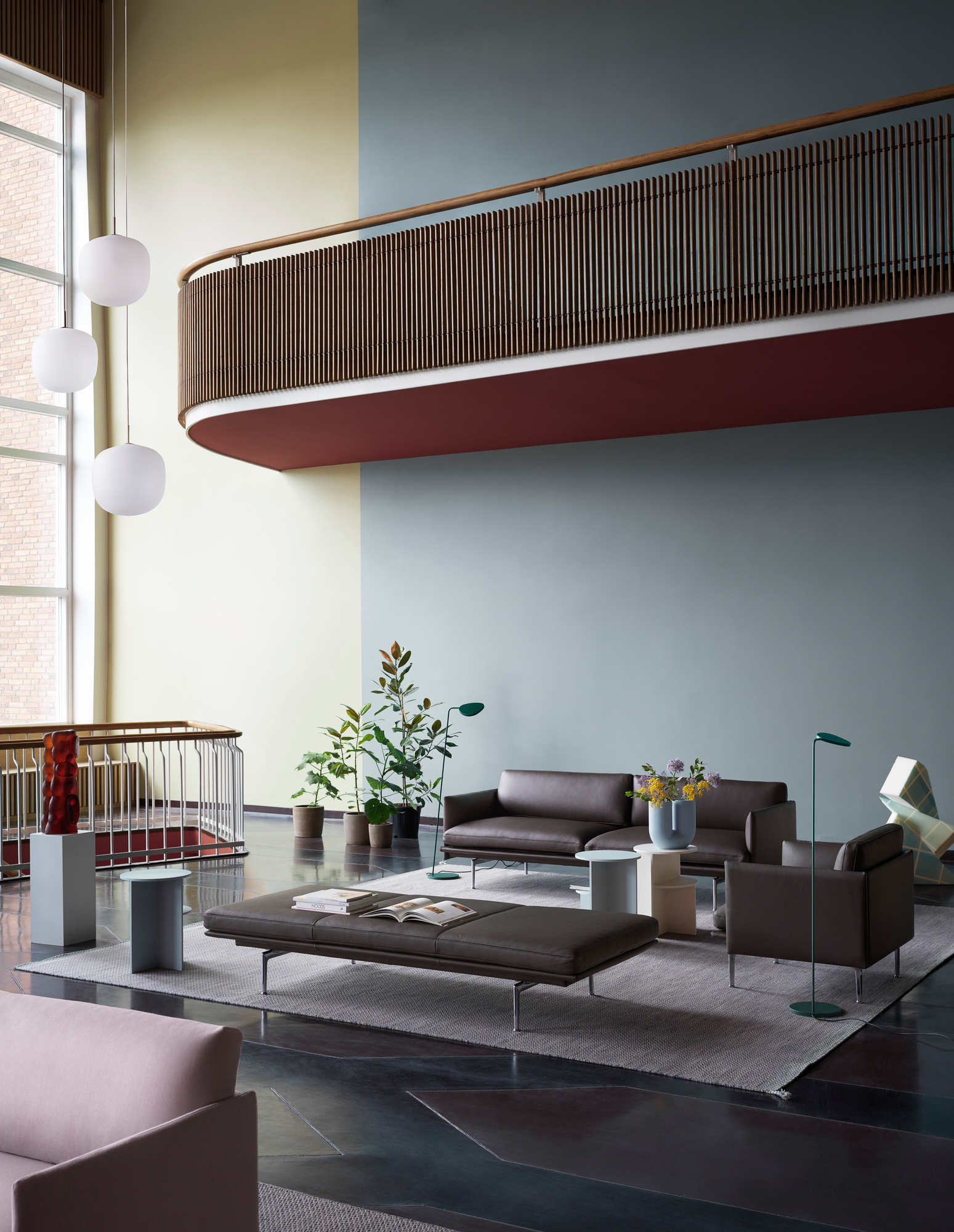 Helle Rime Pendelleuchten von Muuto über einem modern eingerichteten Wohnzimmer mit grauen Möbeln.