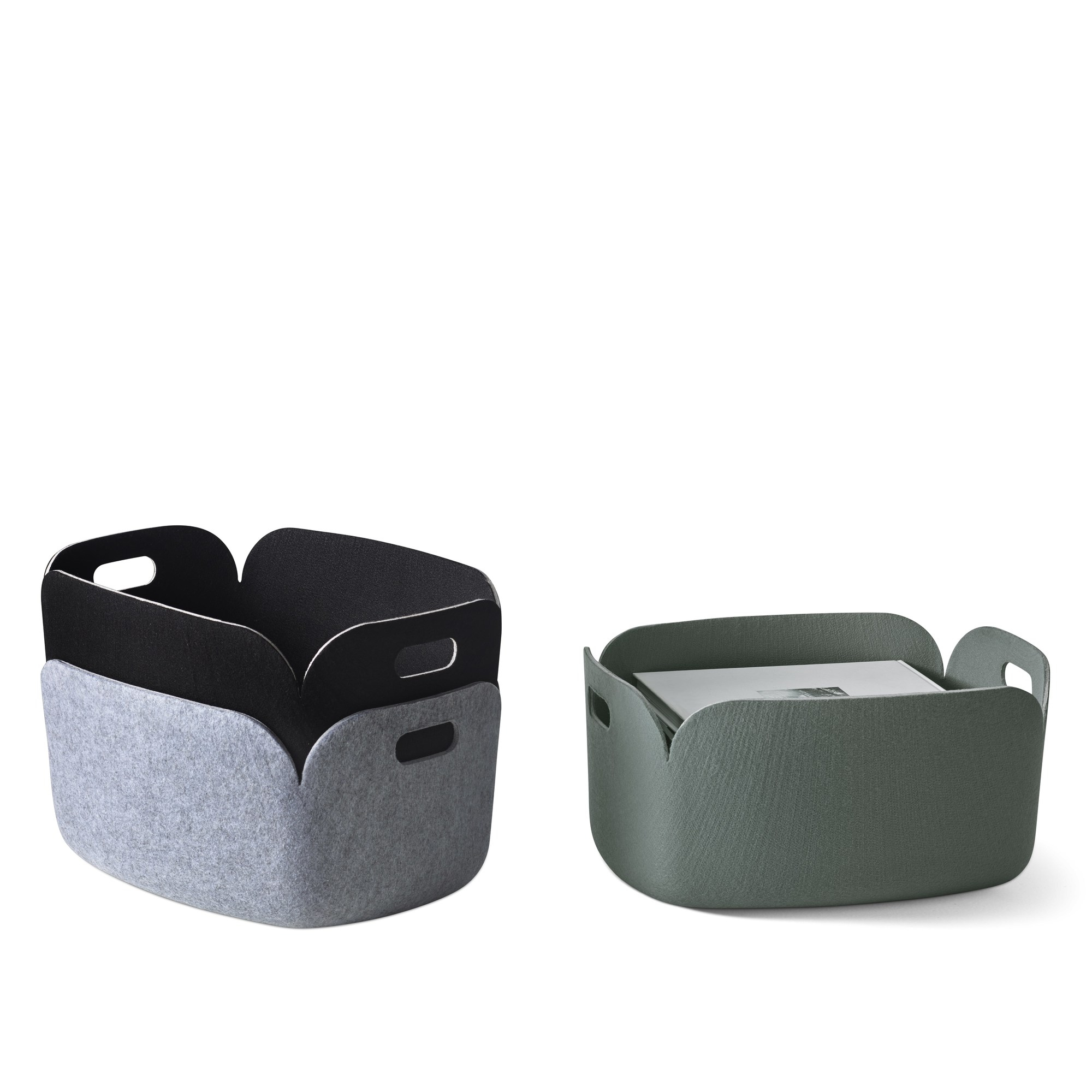 Zwei Muuto Restore Storage Baskets: Einer grau mit schwarzem Innenraum, einer dunkelbraun mit Inhalt. Filz-Aufbewahrungskörbe.