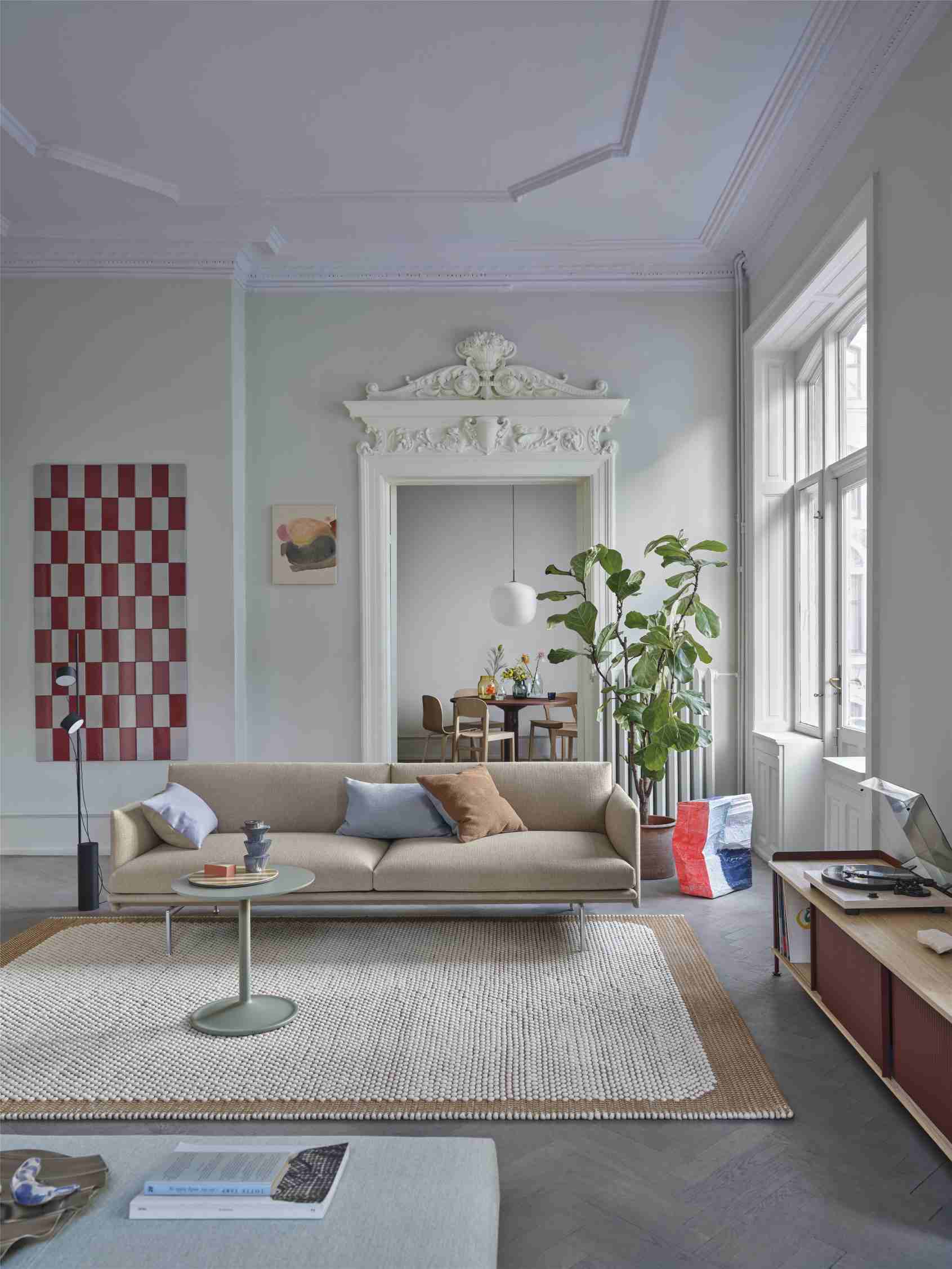 Wohnzimmer mit beigem Sofa, Teppich und Muuto MIDST Table Esstisch im Hintergrund, skandinavisches Design.