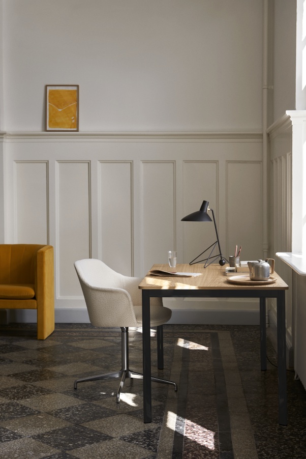 AndTradition Drip Table HW58 mit Stuhl und Lampe in einem stilvollen Arbeitszimmer.