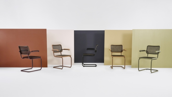 Fünf Thonet S 64 V Freischwinger Stühle in verschiedenen Farben vor farbigen Hintergründen, Stahlrohr Klassiker Design.