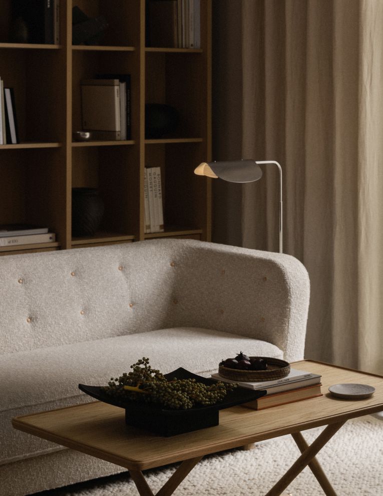Nahaufnahme einer Audo Copenhagen Relevé Platte auf einem Holztisch in einem Wohnzimmer.