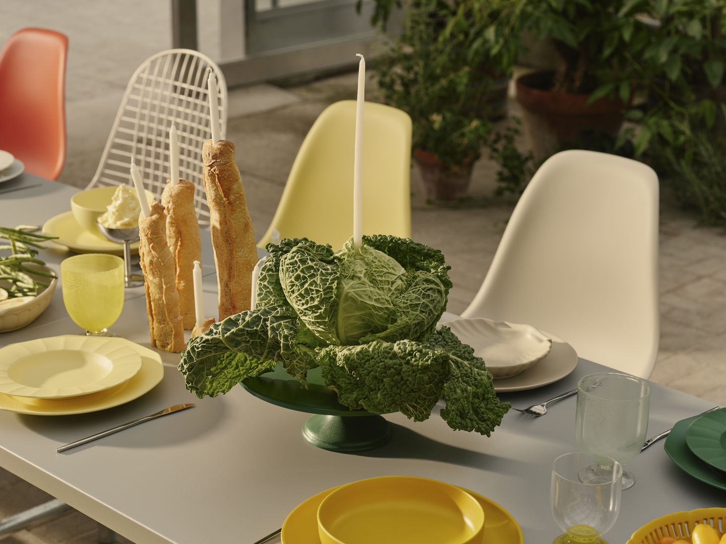 Esstisch mit Geschirr und Vitra Eames Plastic Side Chairs DSR in verschiedenen Farben im Garten.