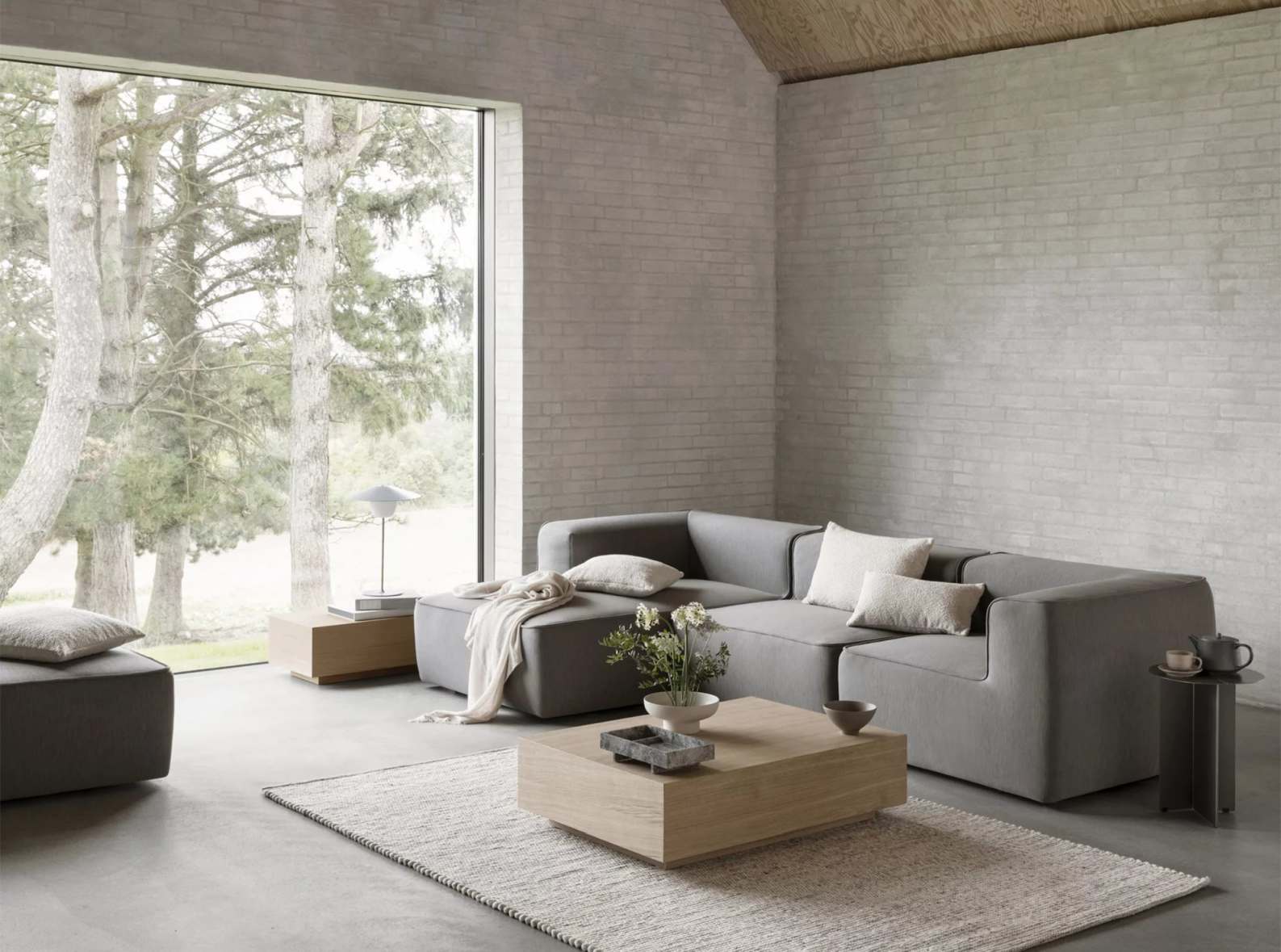 Blomus Goba Couchtisch im Wohnzimmer mit grauer Couch und Teppich. Moderner Wohnstil.