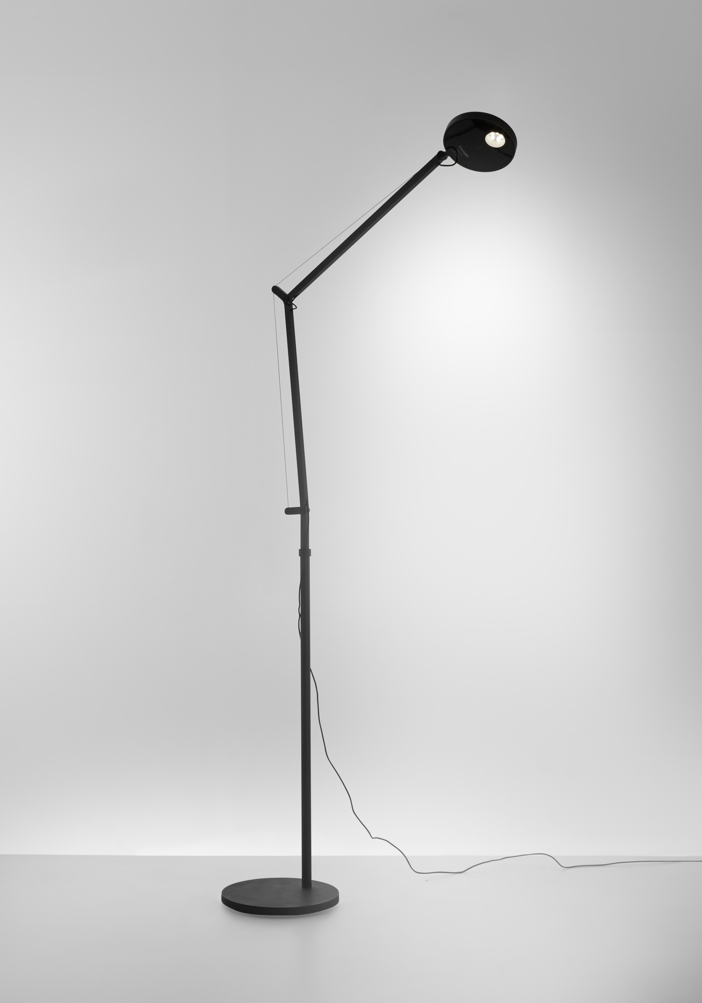 Schwarze Demetra Stehleuchte von Artemide mit verstellbarem Arm und rundem Leuchtenkopf.