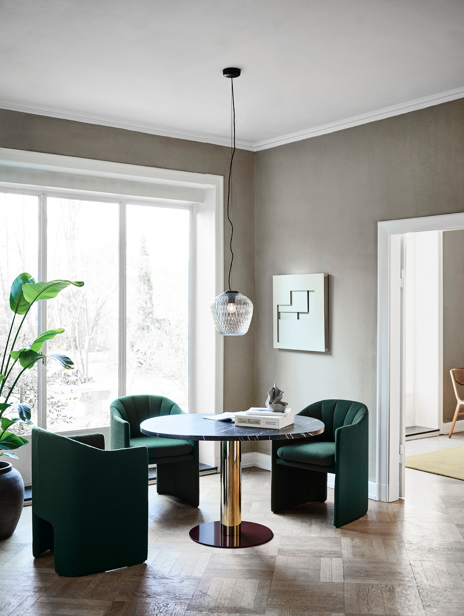 AndTradition Blown SW3 Pendelleuchte über Esstisch mit grünen Stühlen, modernes Design.