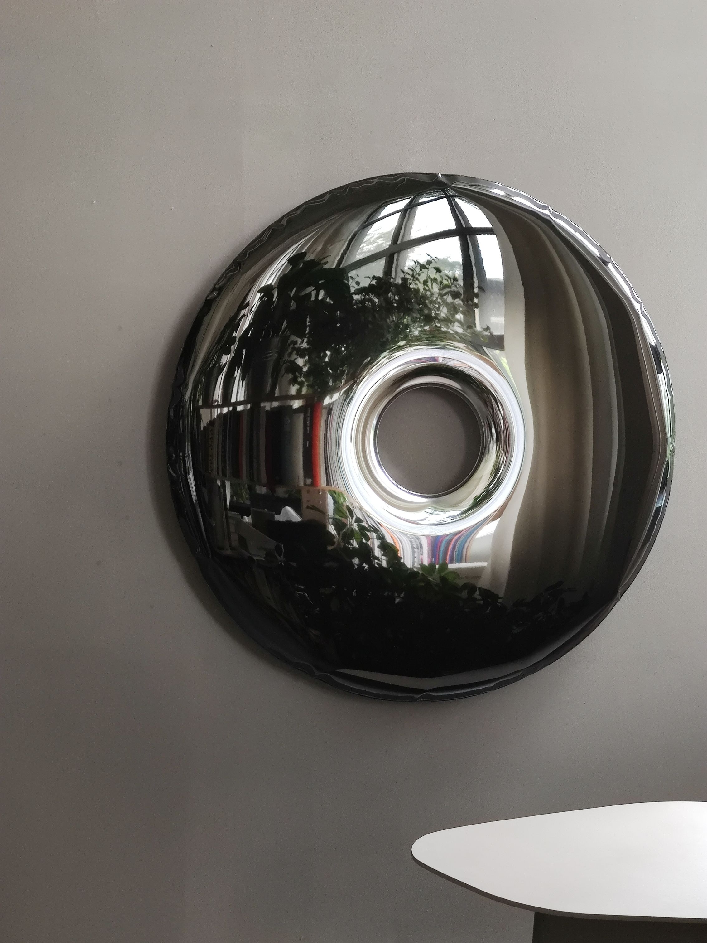 Rondo Wandobjekt von Zieta Studio in dunklem Metall, reflektiert Raum und Licht.