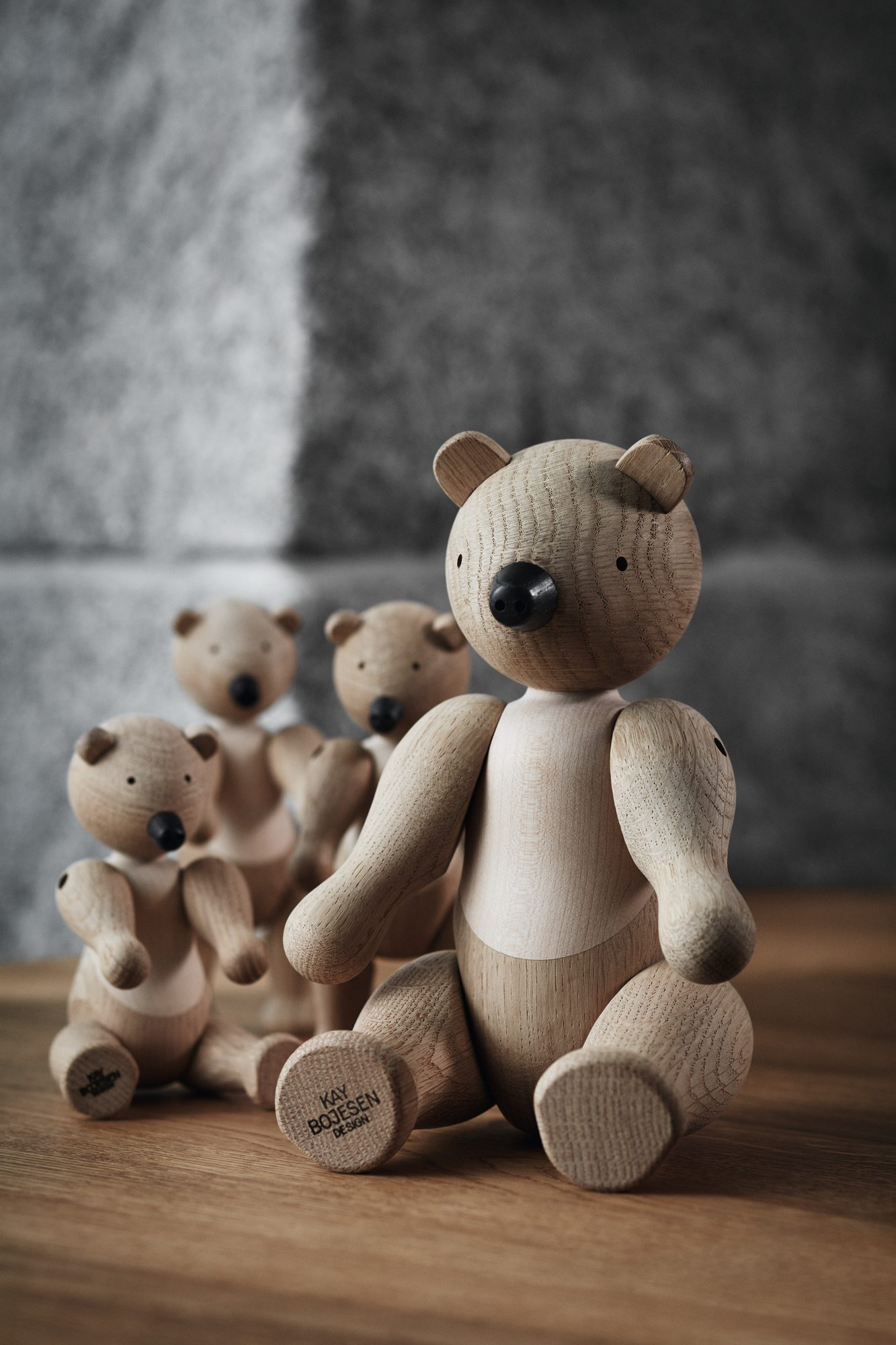 Kay Bojesen Bär Holzfigur, mittelgroß, als Deko-Objekt und Sammlerstück, mit weiteren Bären im Hintergrund.